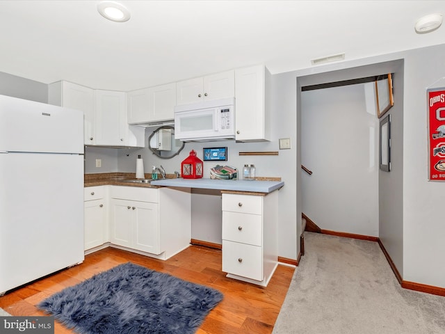 kitchen featuring white cabinetry, sink, white appliances, and light hardwood / wood-style flooring