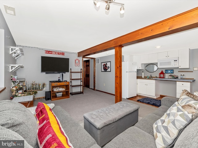 carpeted living room with sink and beam ceiling