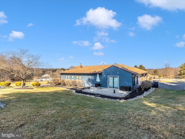 rear view of house featuring a yard and a patio area