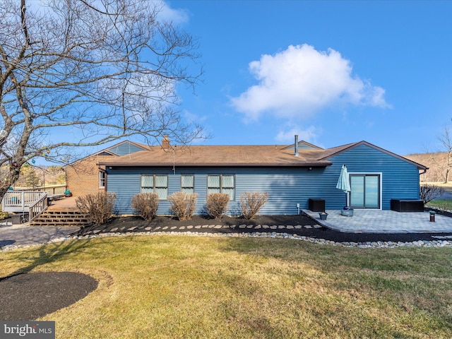 back of house featuring a yard, a deck, and a patio