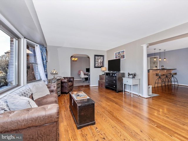 living room with light hardwood / wood-style flooring and ornate columns