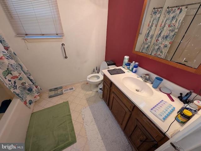 bathroom with vanity, curtained shower, and toilet