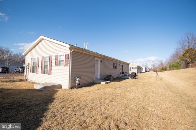 view of side of home featuring a yard and central AC unit