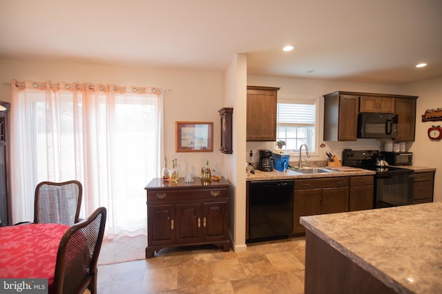 kitchen with black appliances, light countertops, a sink, and recessed lighting