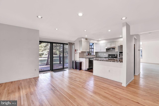 kitchen with white cabinetry, appliances with stainless steel finishes, light hardwood / wood-style floors, and decorative backsplash