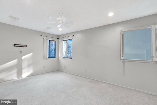 carpeted spare room featuring ceiling fan