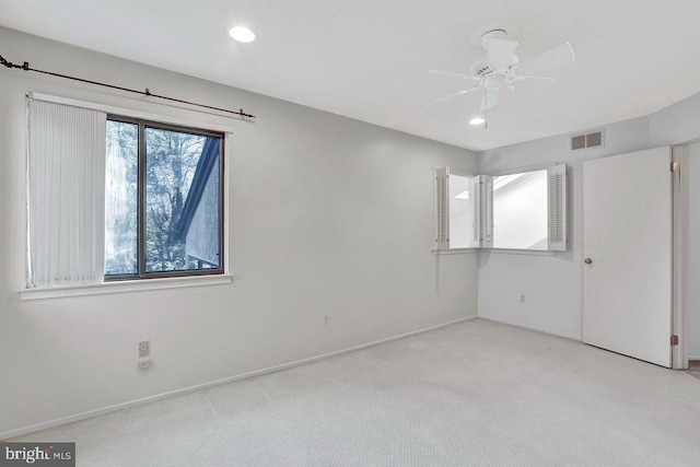 carpeted spare room featuring ceiling fan