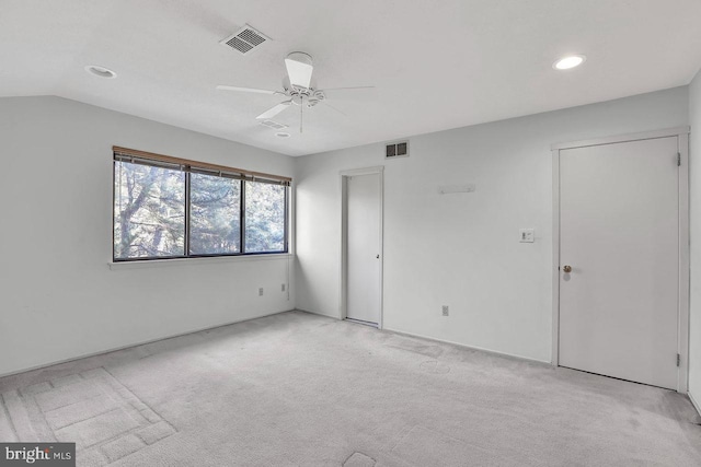 unfurnished bedroom featuring lofted ceiling, light colored carpet, and ceiling fan