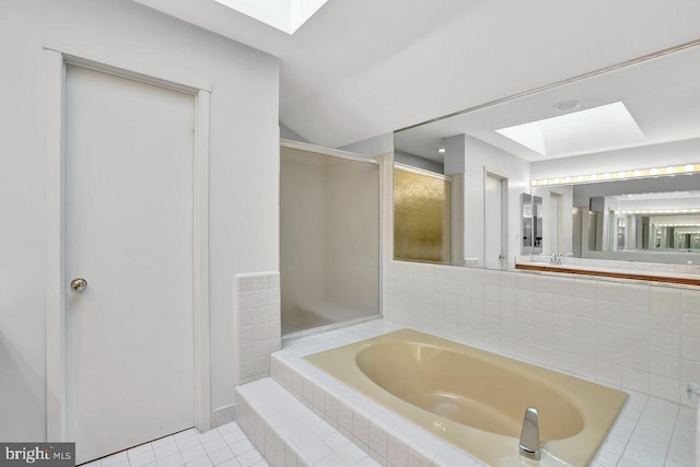 bathroom with shower with separate bathtub, tile patterned floors, and a skylight