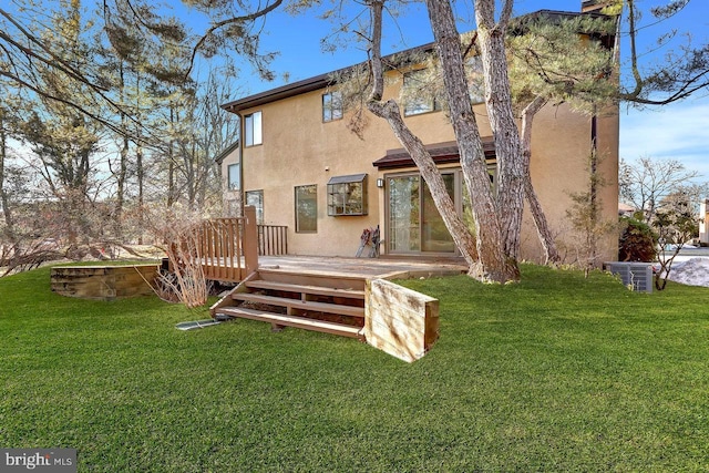 rear view of house featuring a lawn and a deck