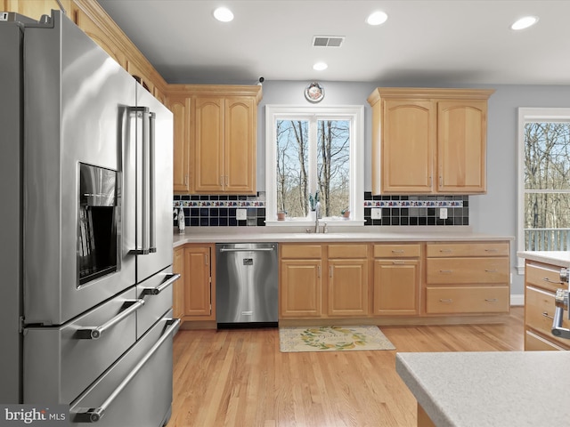 kitchen with light countertops, appliances with stainless steel finishes, light brown cabinets, and visible vents