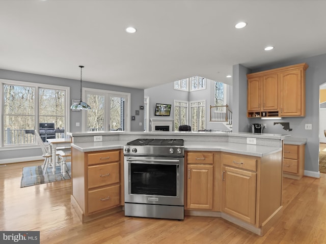 kitchen featuring light wood finished floors, gas stove, decorative light fixtures, and recessed lighting