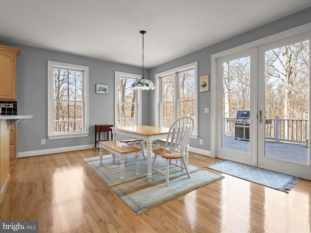 dining room with light wood-style floors, baseboards, visible vents, and french doors