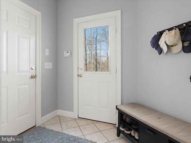 doorway to outside with baseboards and light tile patterned floors