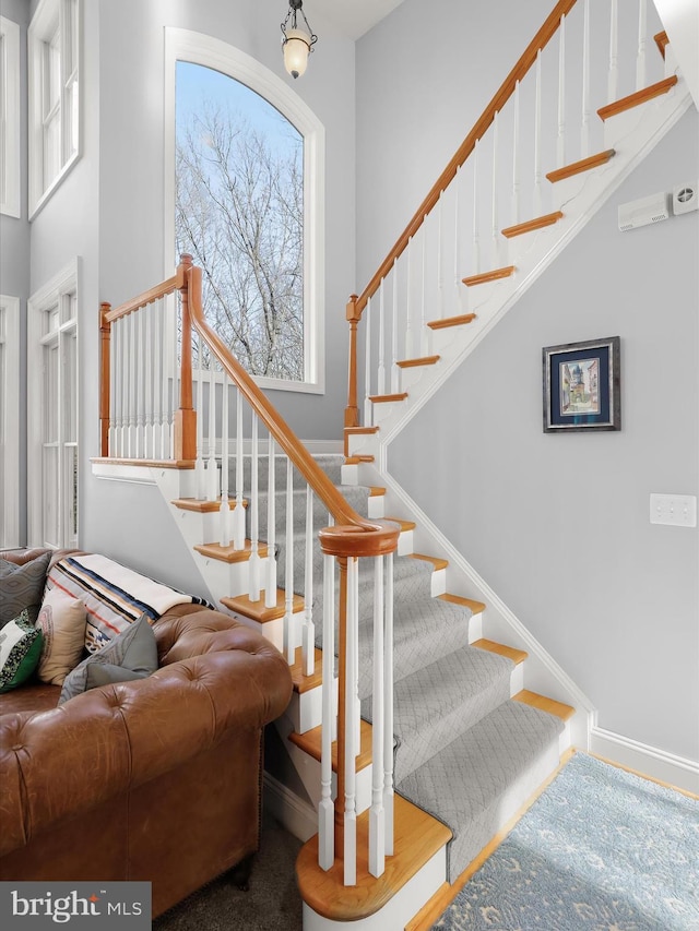 stairs with a high ceiling and baseboards