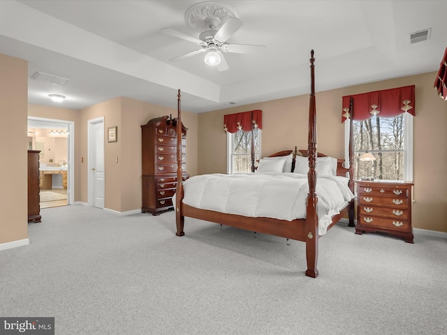 bedroom with a raised ceiling, visible vents, and baseboards