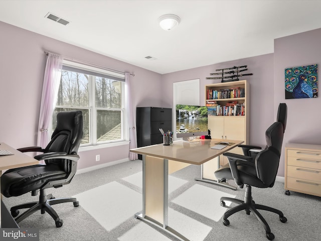 office with baseboards, visible vents, and light colored carpet