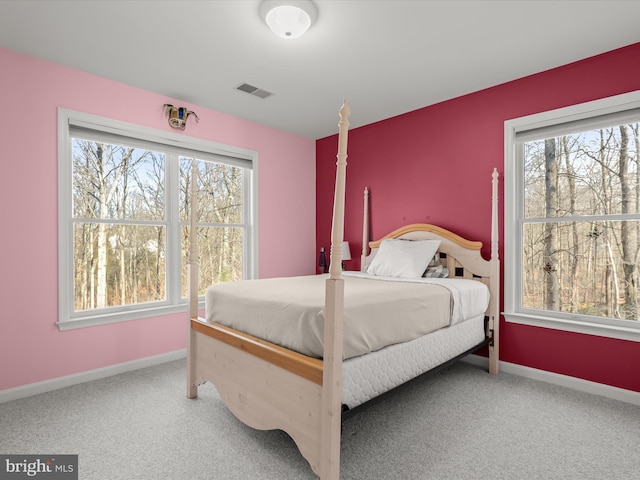 bedroom with baseboards, multiple windows, visible vents, and carpet flooring