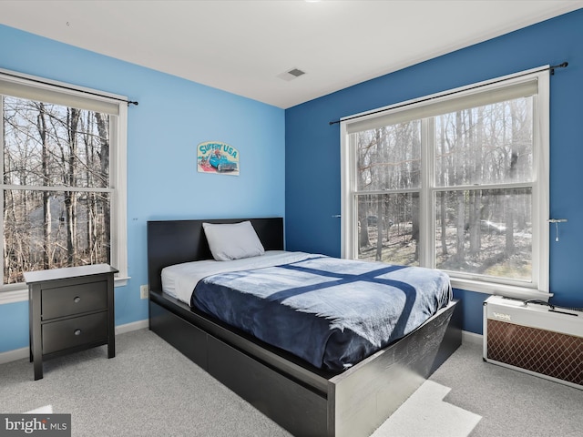 bedroom featuring multiple windows, visible vents, and baseboards