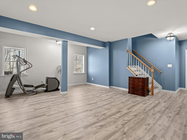 exercise area featuring light wood-type flooring, plenty of natural light, and baseboards