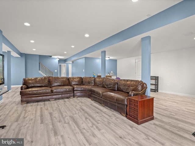 living area featuring light wood-type flooring, baseboards, recessed lighting, and stairs