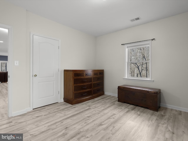 unfurnished bedroom with light wood-style flooring, visible vents, and baseboards