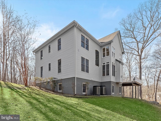 view of home's exterior featuring cooling unit and a lawn