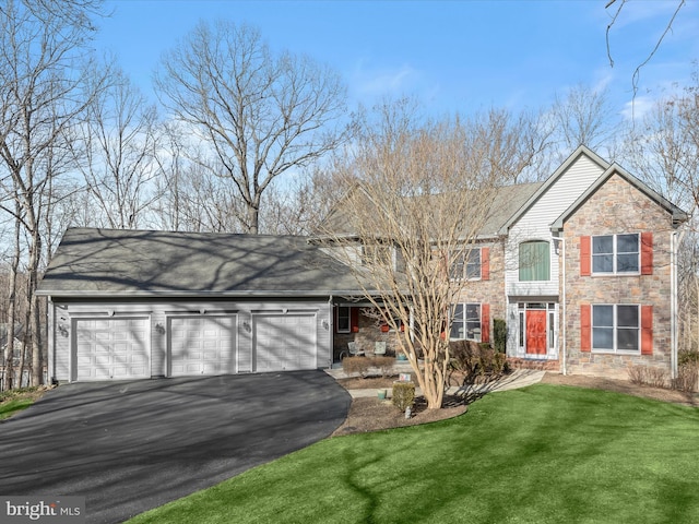 traditional-style house featuring aphalt driveway, a front yard, stone siding, and a garage