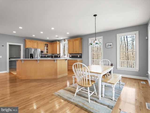 dining area featuring baseboards, light wood-style flooring, and recessed lighting