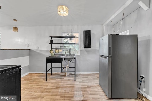 kitchen featuring sink, light hardwood / wood-style flooring, and stainless steel refrigerator