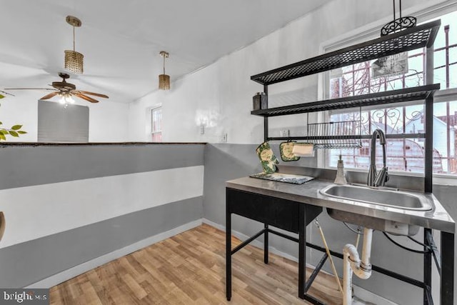 office featuring sink, light hardwood / wood-style flooring, and ceiling fan