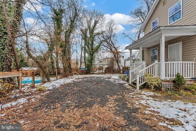 snowy yard with covered porch