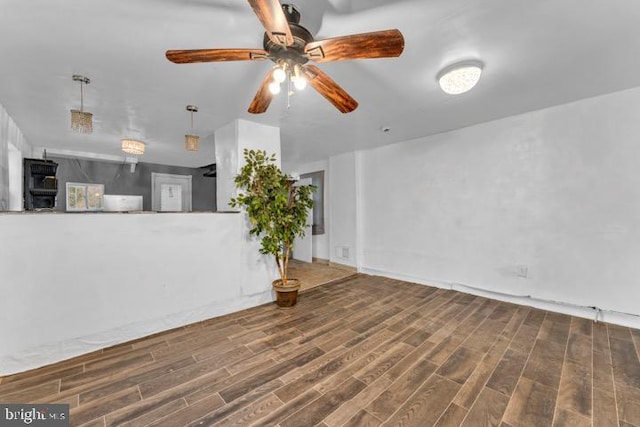 unfurnished living room with ceiling fan and dark hardwood / wood-style flooring