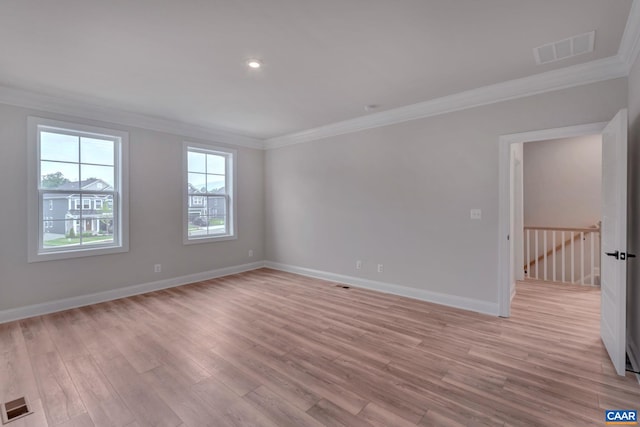 spare room with crown molding and light wood-type flooring