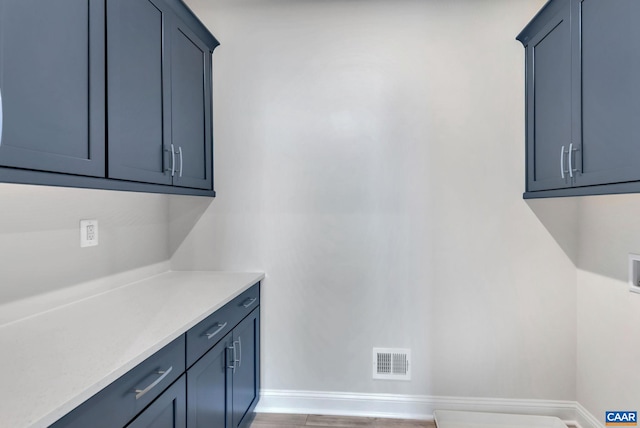 clothes washing area with cabinets, dark wood-type flooring, and washer hookup