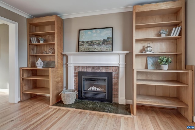 unfurnished living room with crown molding, built in shelves, and light hardwood / wood-style flooring