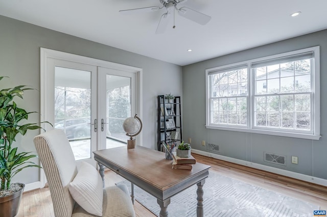 office space featuring french doors, ceiling fan, and light wood-type flooring