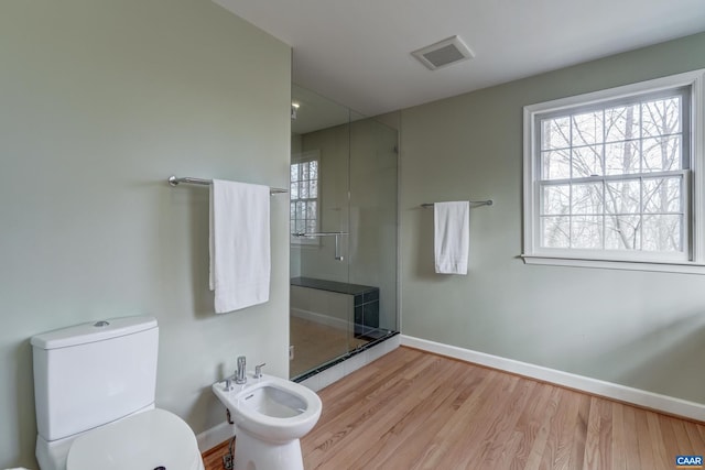 bathroom featuring a bidet, an enclosed shower, hardwood / wood-style floors, and a wealth of natural light