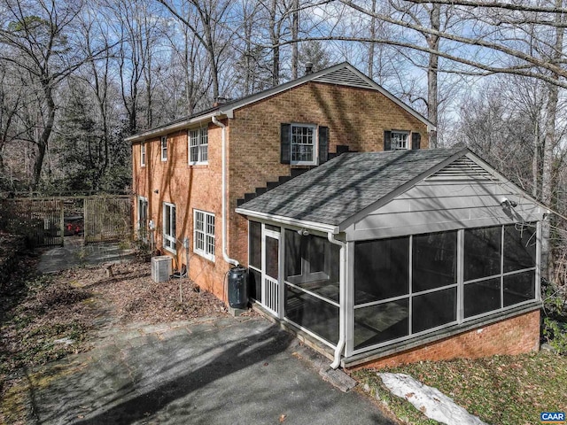 back of property featuring central AC and a sunroom