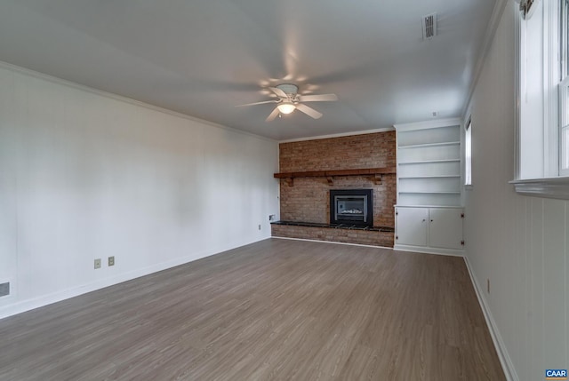 unfurnished living room featuring crown molding, hardwood / wood-style floors, ceiling fan, and built in shelves