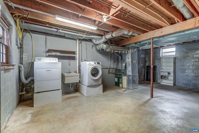 basement with separate washer and dryer, sink, and heating unit