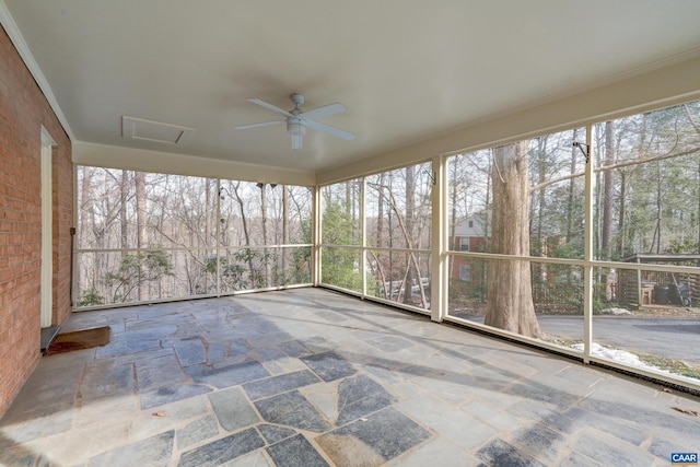 unfurnished sunroom featuring ceiling fan