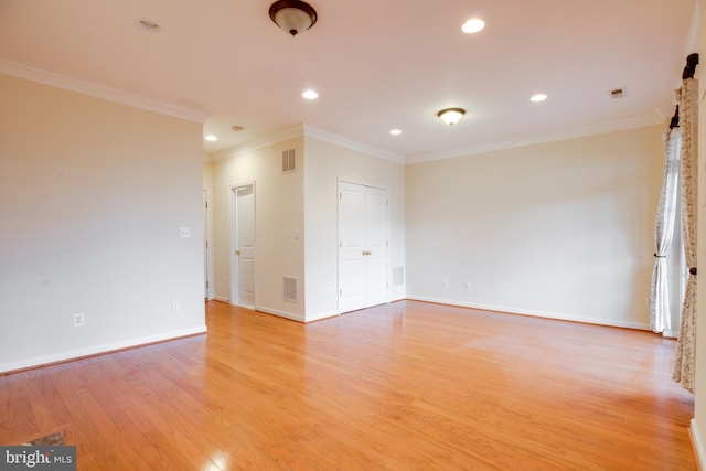 empty room with crown molding and light wood-type flooring