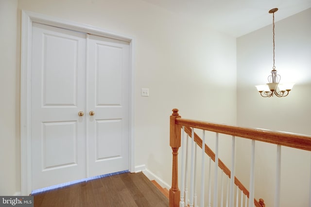 corridor featuring hardwood / wood-style flooring and a chandelier