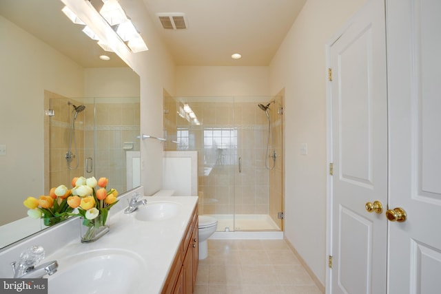 bathroom featuring vanity, a shower with shower door, tile patterned floors, and toilet