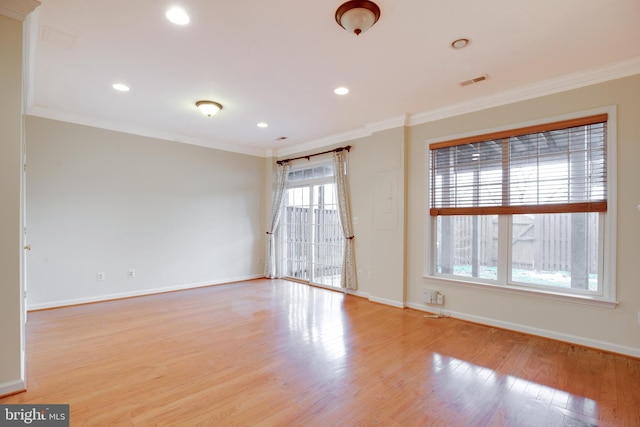 spare room featuring ornamental molding and light hardwood / wood-style flooring