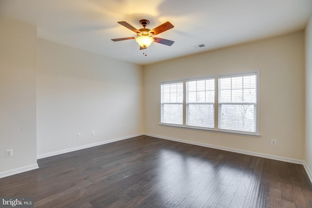 empty room featuring dark wood-type flooring and ceiling fan