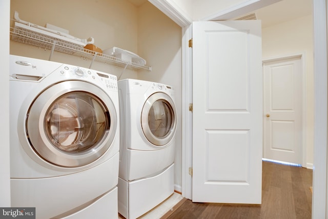 clothes washing area with washer and dryer and dark hardwood / wood-style floors