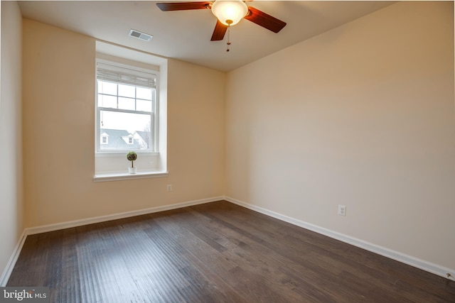 spare room with dark wood-type flooring and ceiling fan