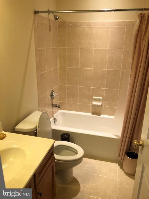 full bathroom with shower / bath combination with curtain, tile patterned floors, toilet, and vanity